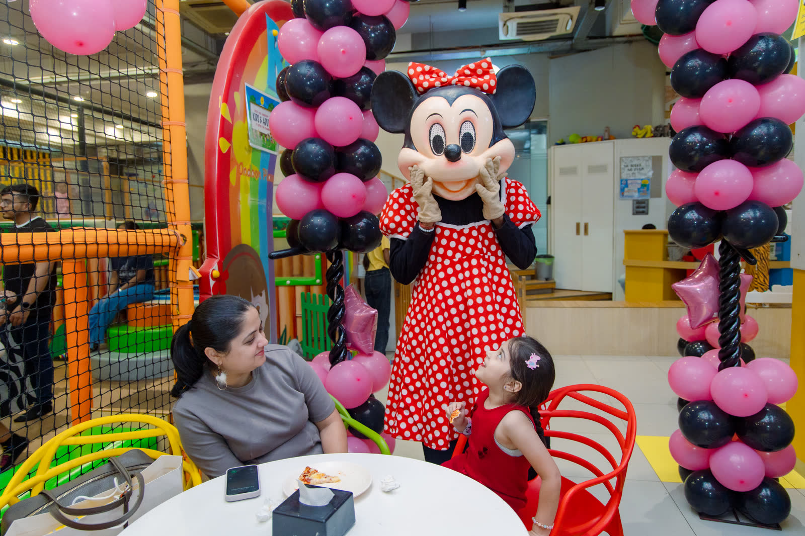 Costumed character greeting a child beside birthday balloons at Baccha Party Malad