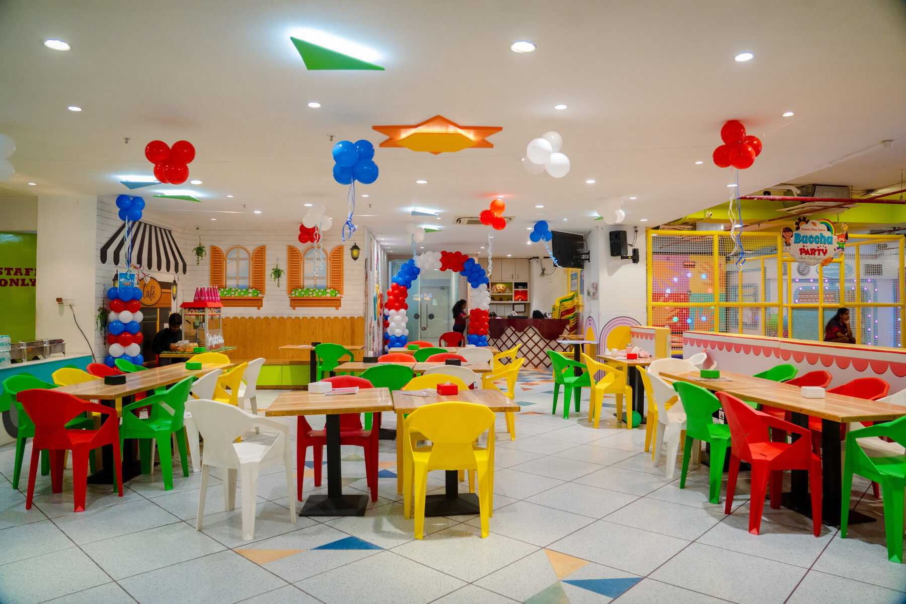 Colourful party hall with kid-sized tables and chairs set up for a birthday at Baccha Party Powai