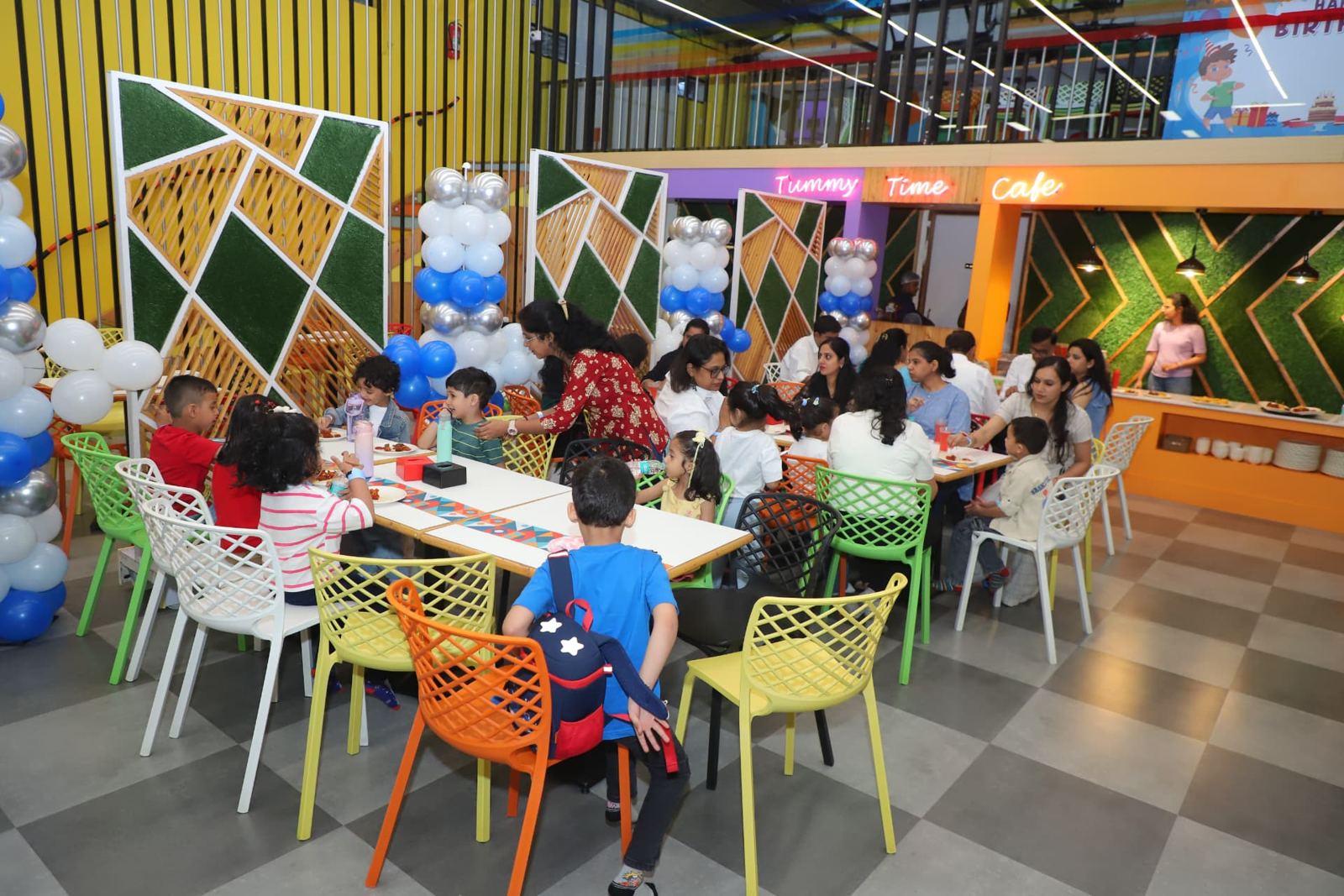 Children and parents at party tables in the Tummy Time Café area at Baccha Party Thane