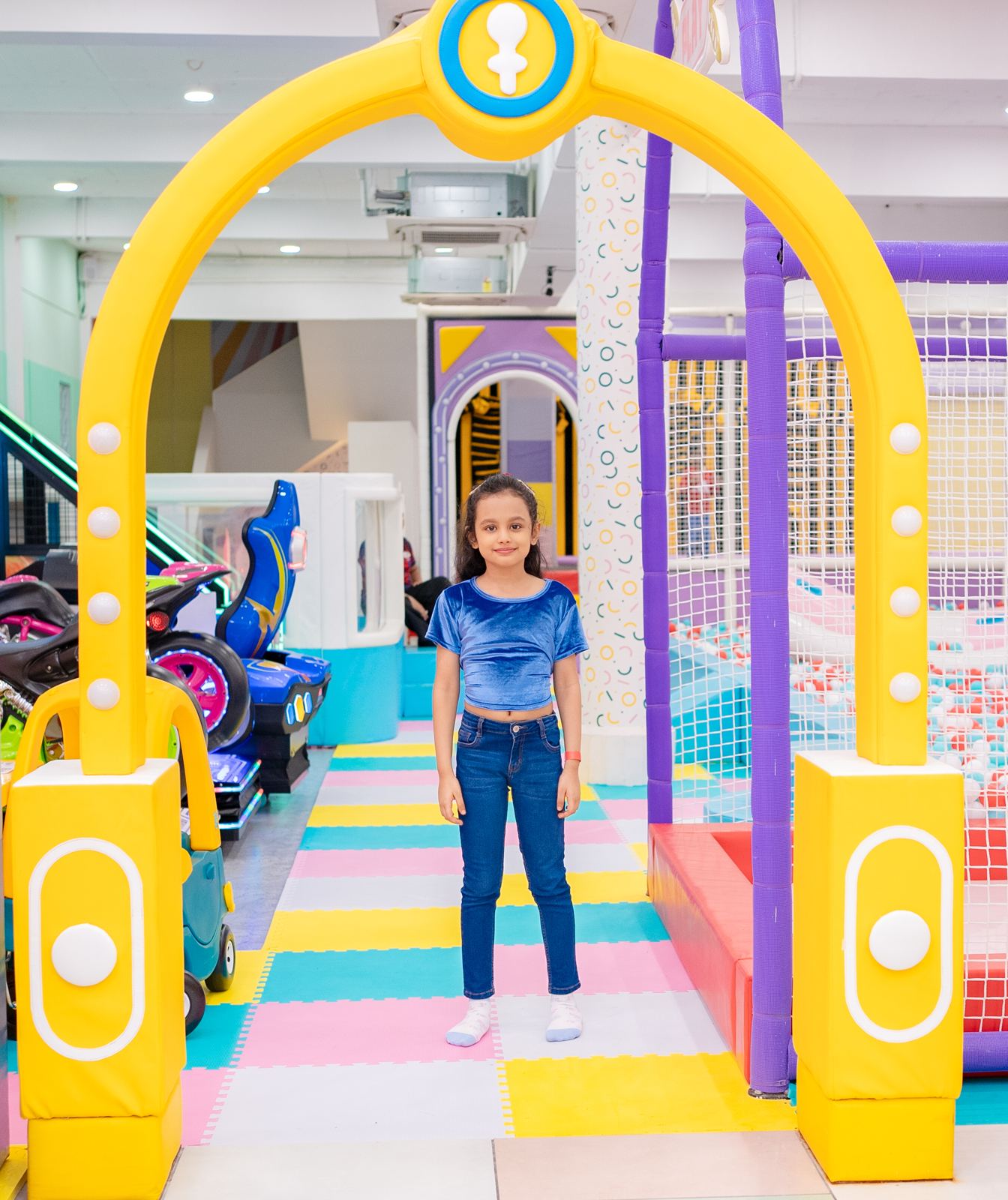 Girl standing under the yellow entrance arch at Baccha Party Matunga