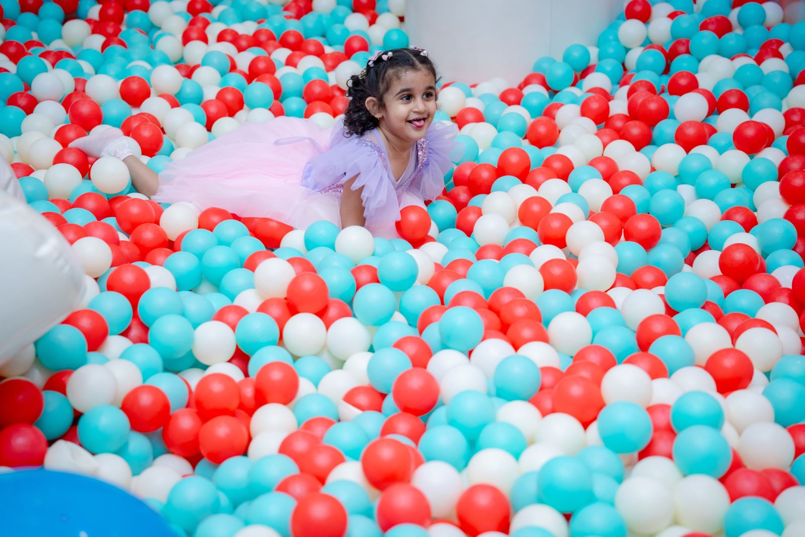 Toddler in a party dress playing in the ball pit at Baccha Party Matunga