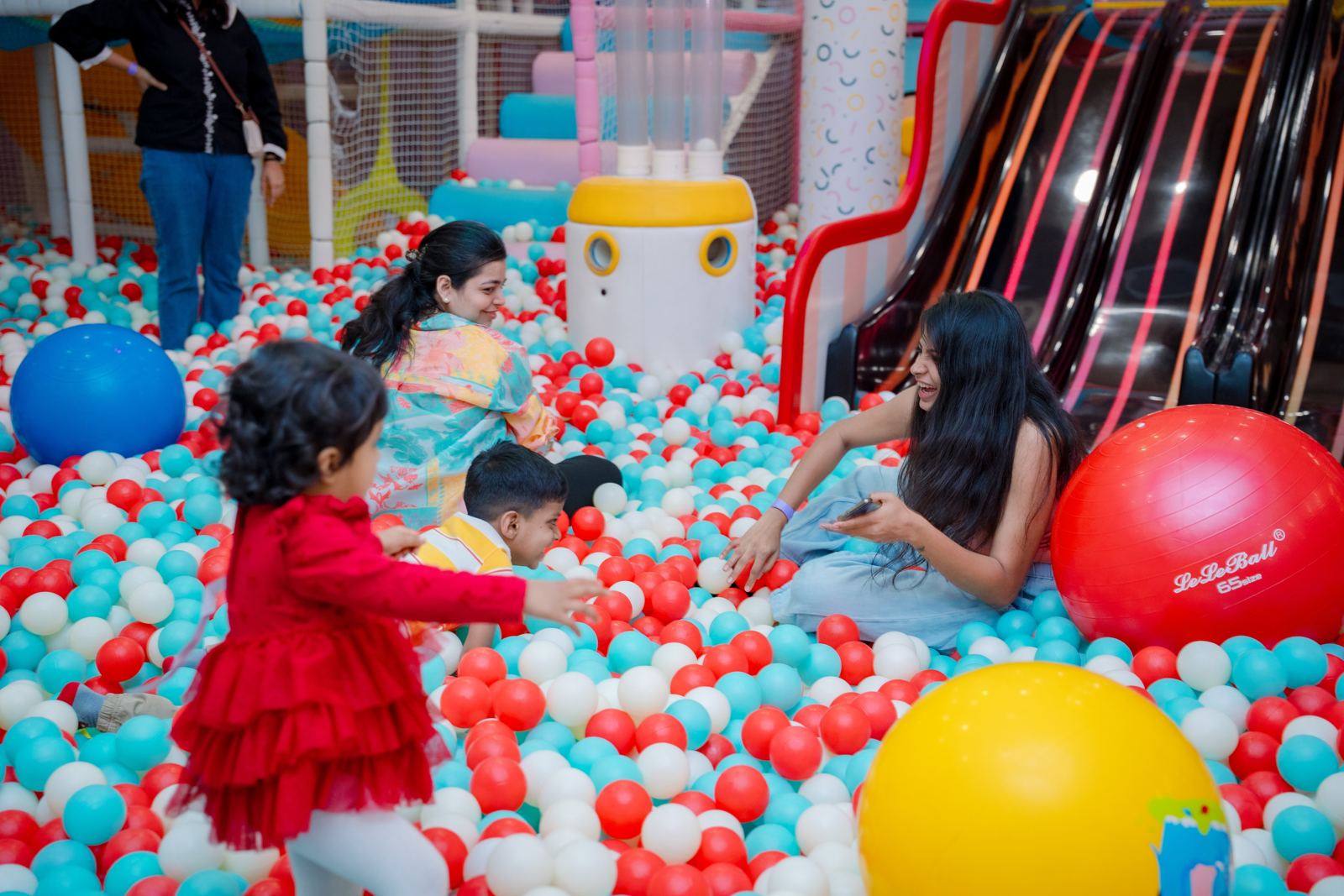 Parents and toddlers playing at the foot of the wave slides at Baccha Party Matunga