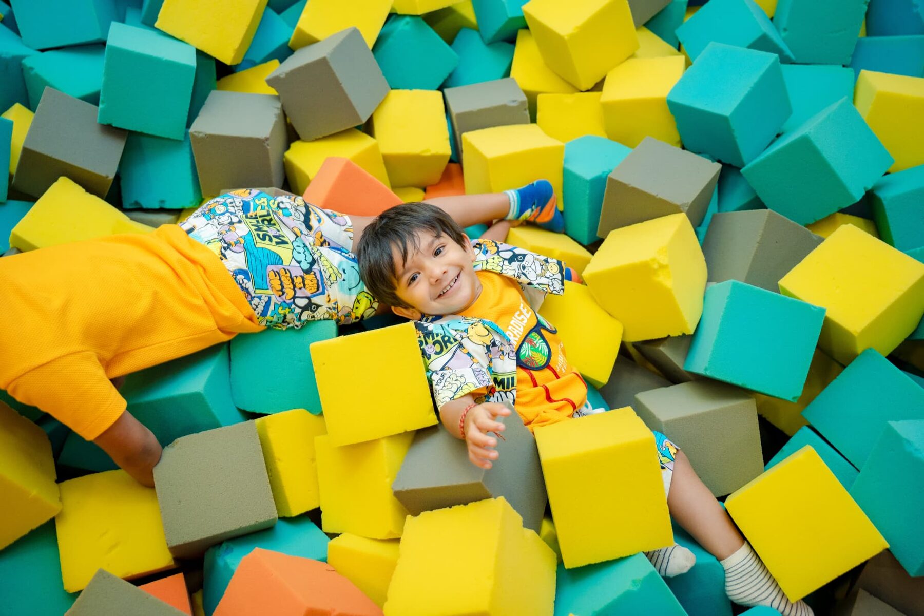Child laughing in the foam block pit at Baccha Party Powai