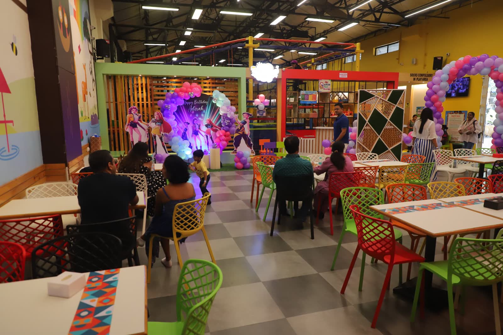 Birthday celebration around party tables and a personalised backdrop at Baccha Party Thane