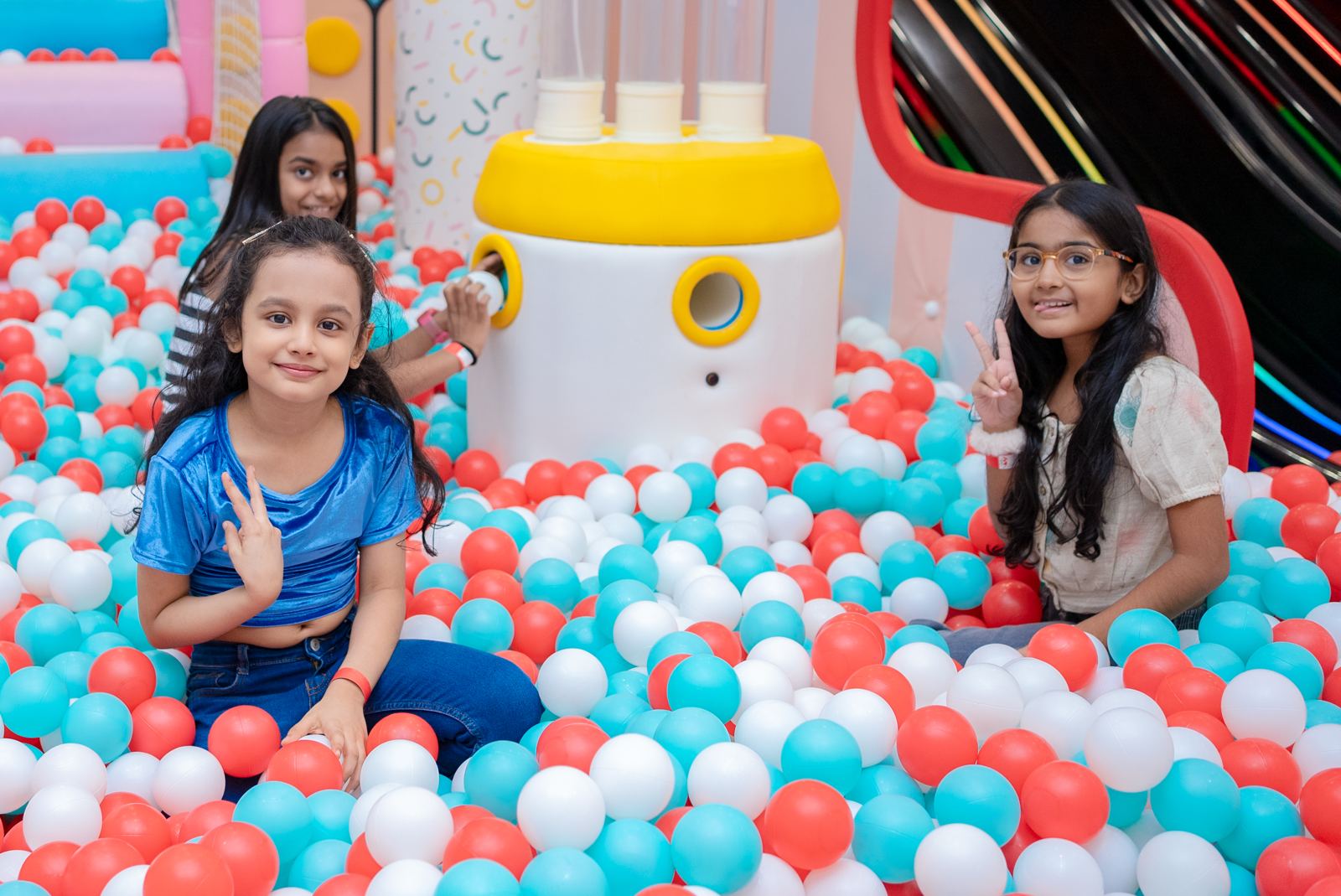 Three girls smiling in the ball pit at Baccha Party Matunga