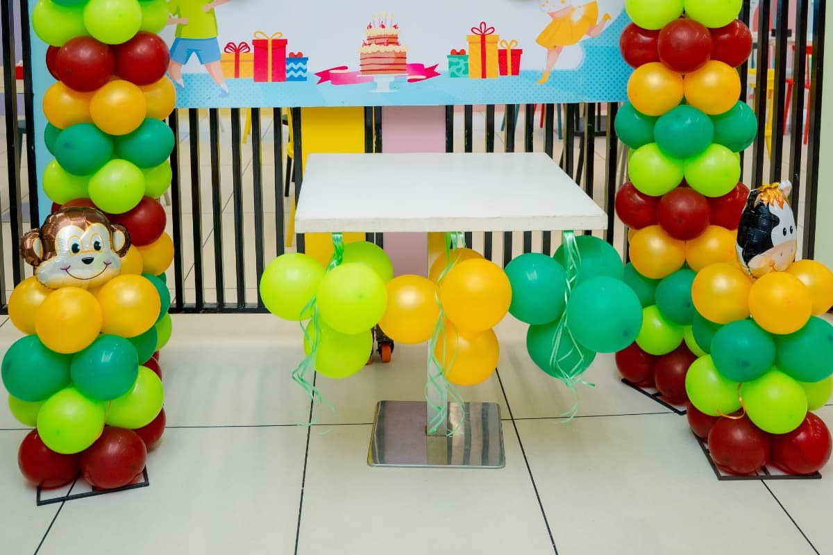 Jungle-theme balloon arch and cake table set up for a birthday at Baccha Party Matunga