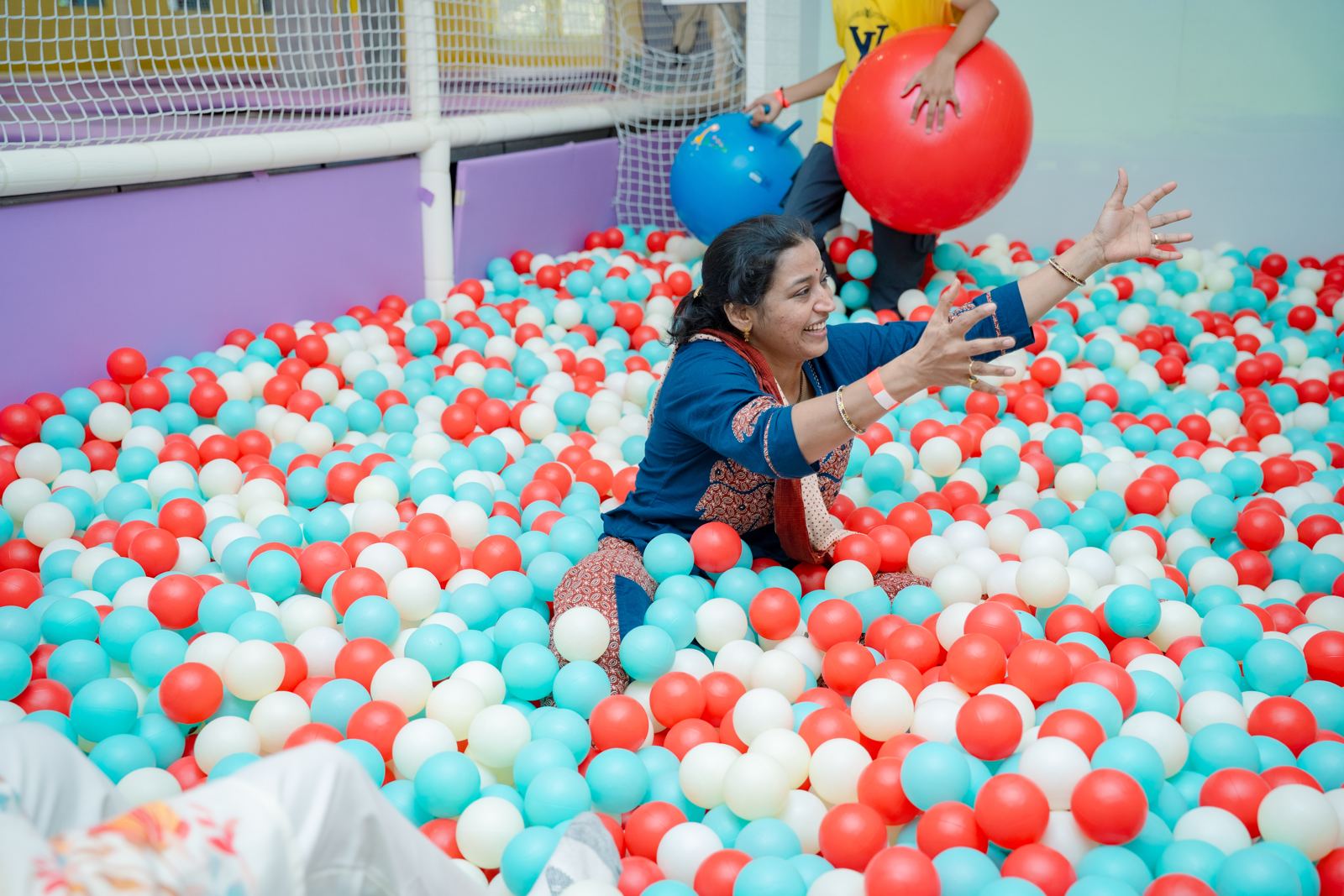 Parent playing catch in the ball pit at Baccha Party Matunga