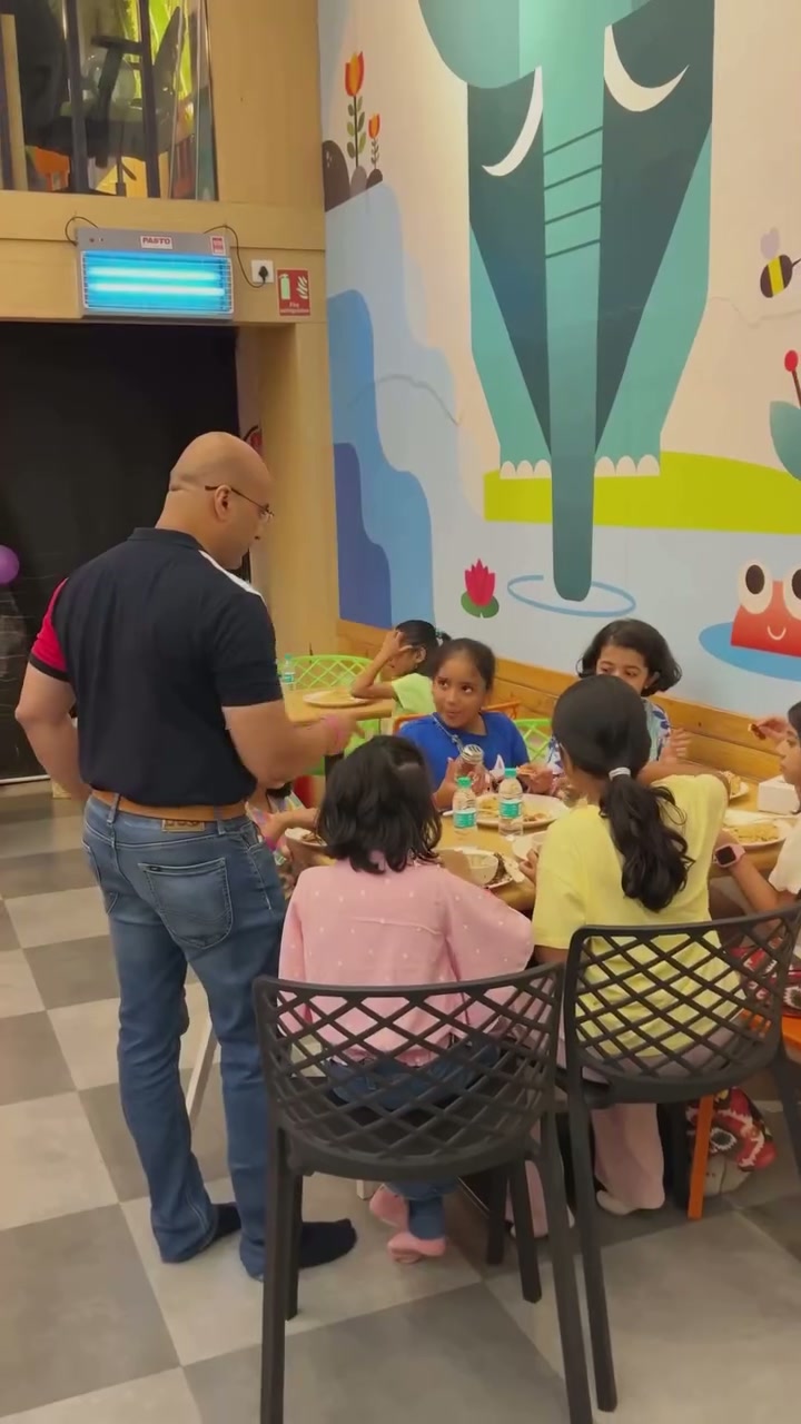 Children and parents gathered around a birthday party table at Baccha Party Thane