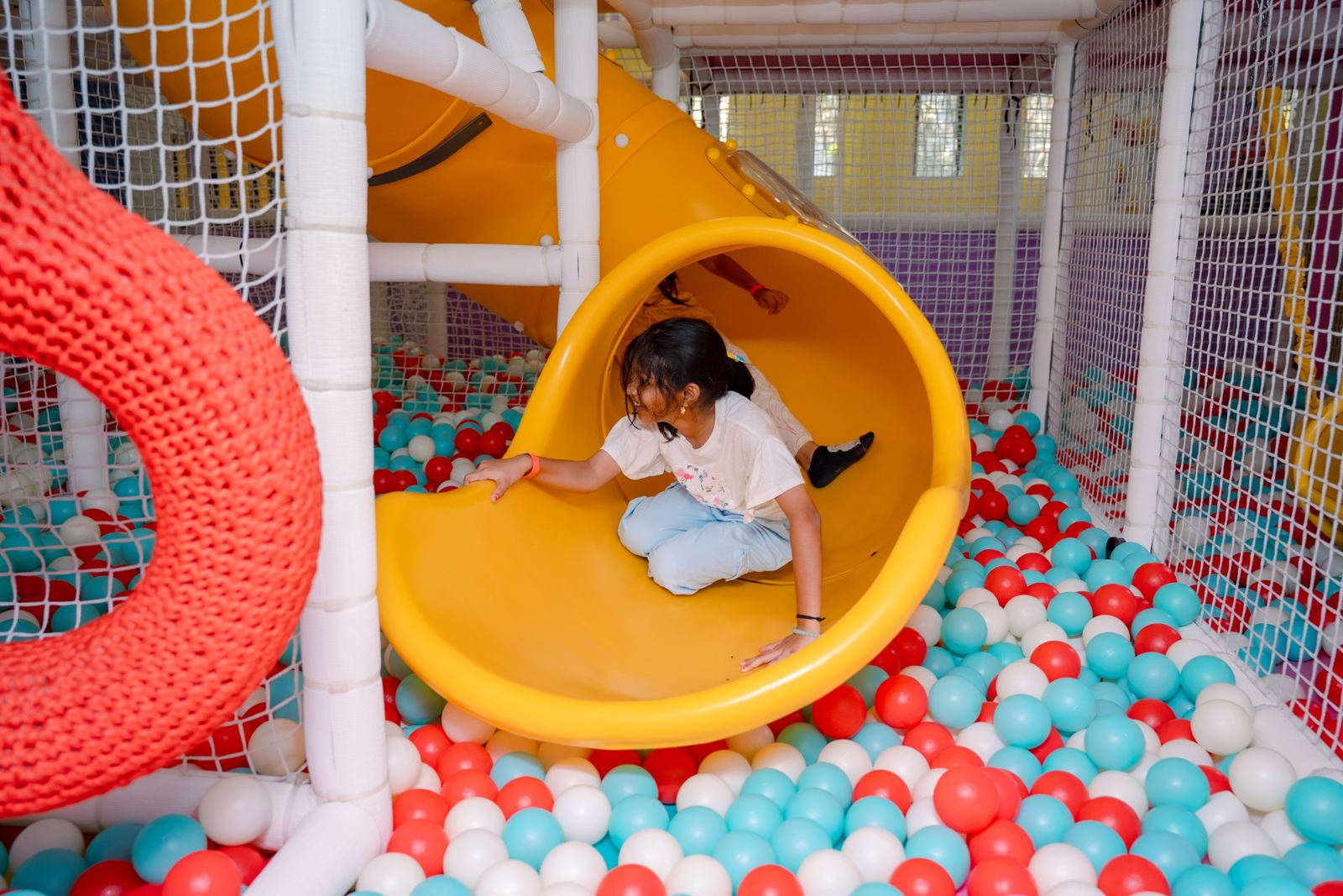 Girl coming out of the yellow spiral slide at Baccha Party Matunga