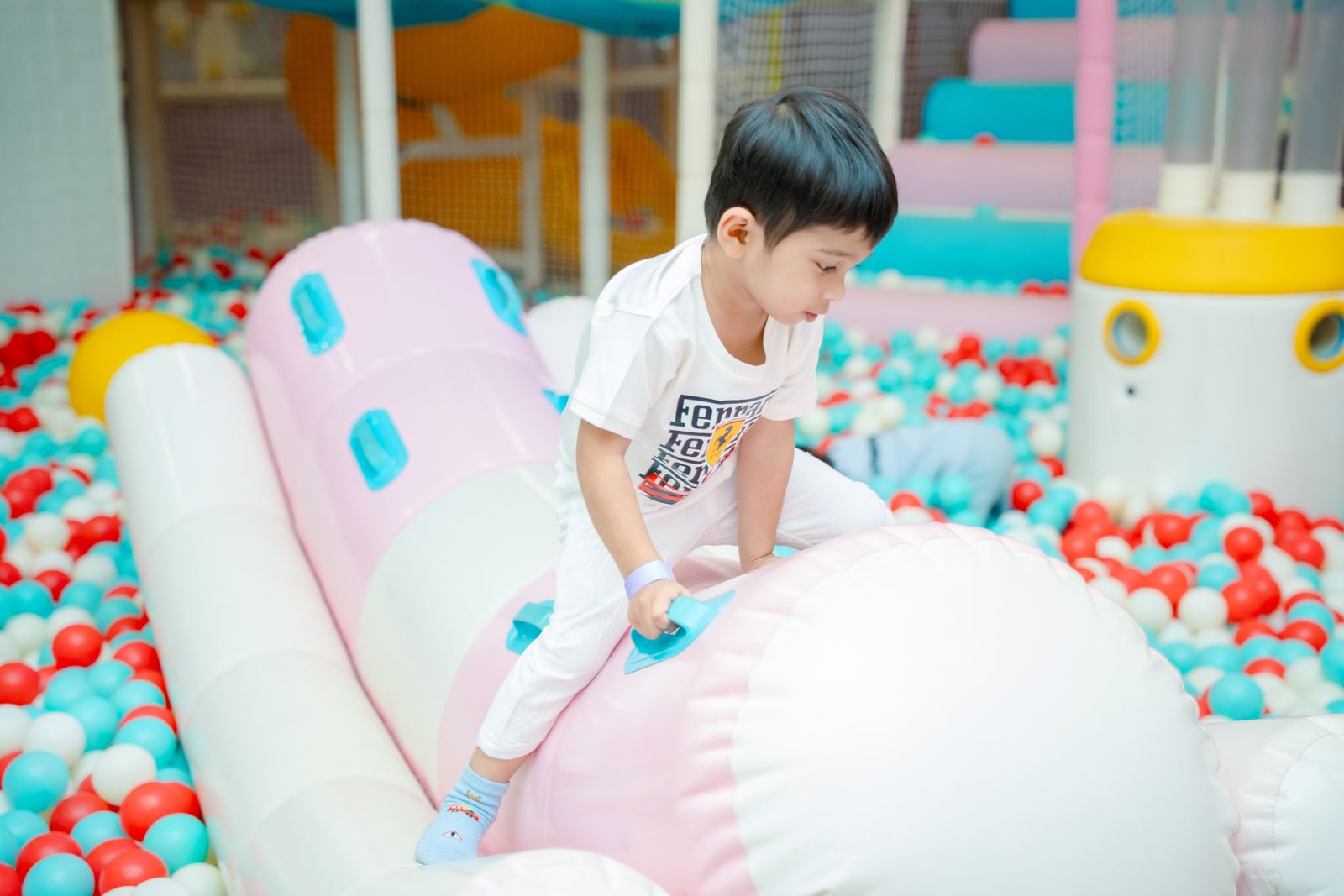 Young boy climbing the inflatable in the ball pit at Baccha Party Matunga