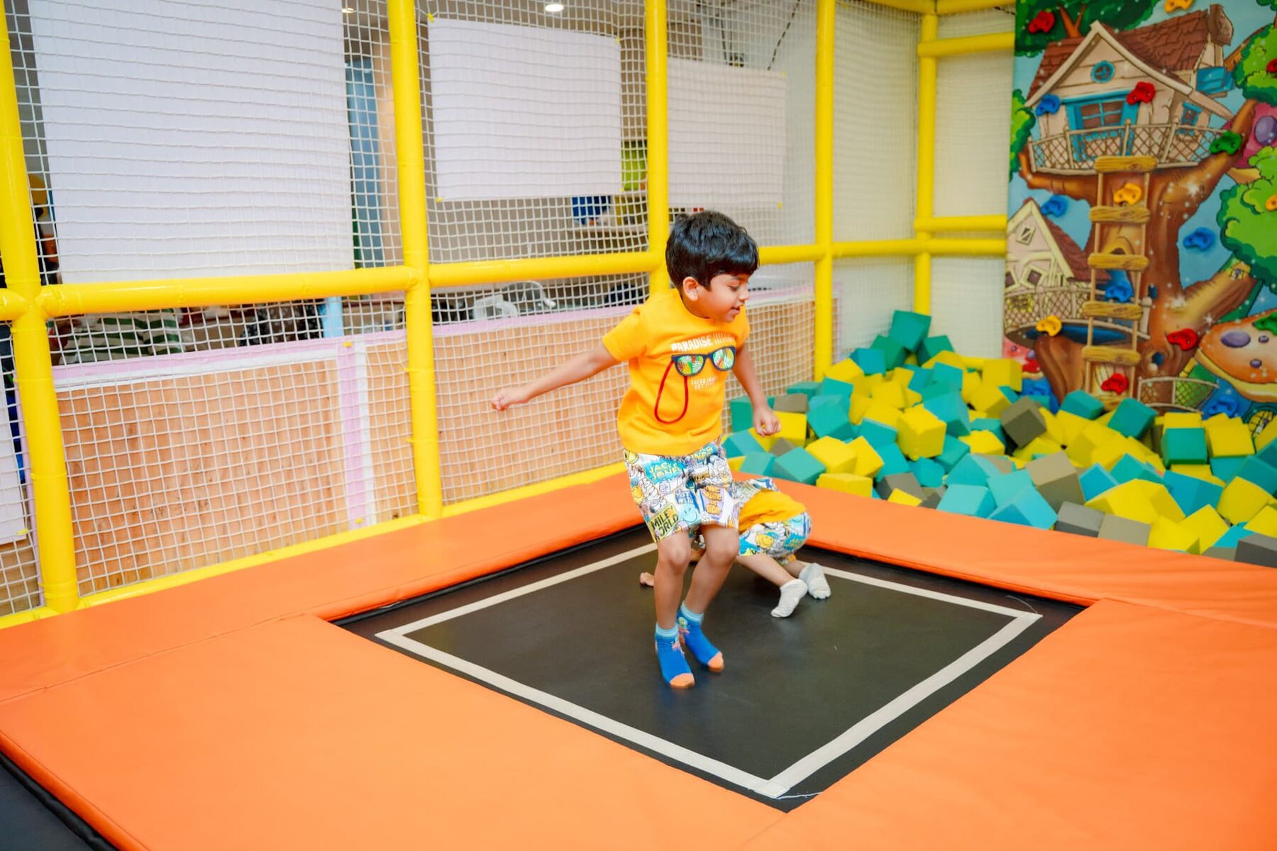 Boy bouncing on a trampoline next to the foam pit at Baccha Party Powai