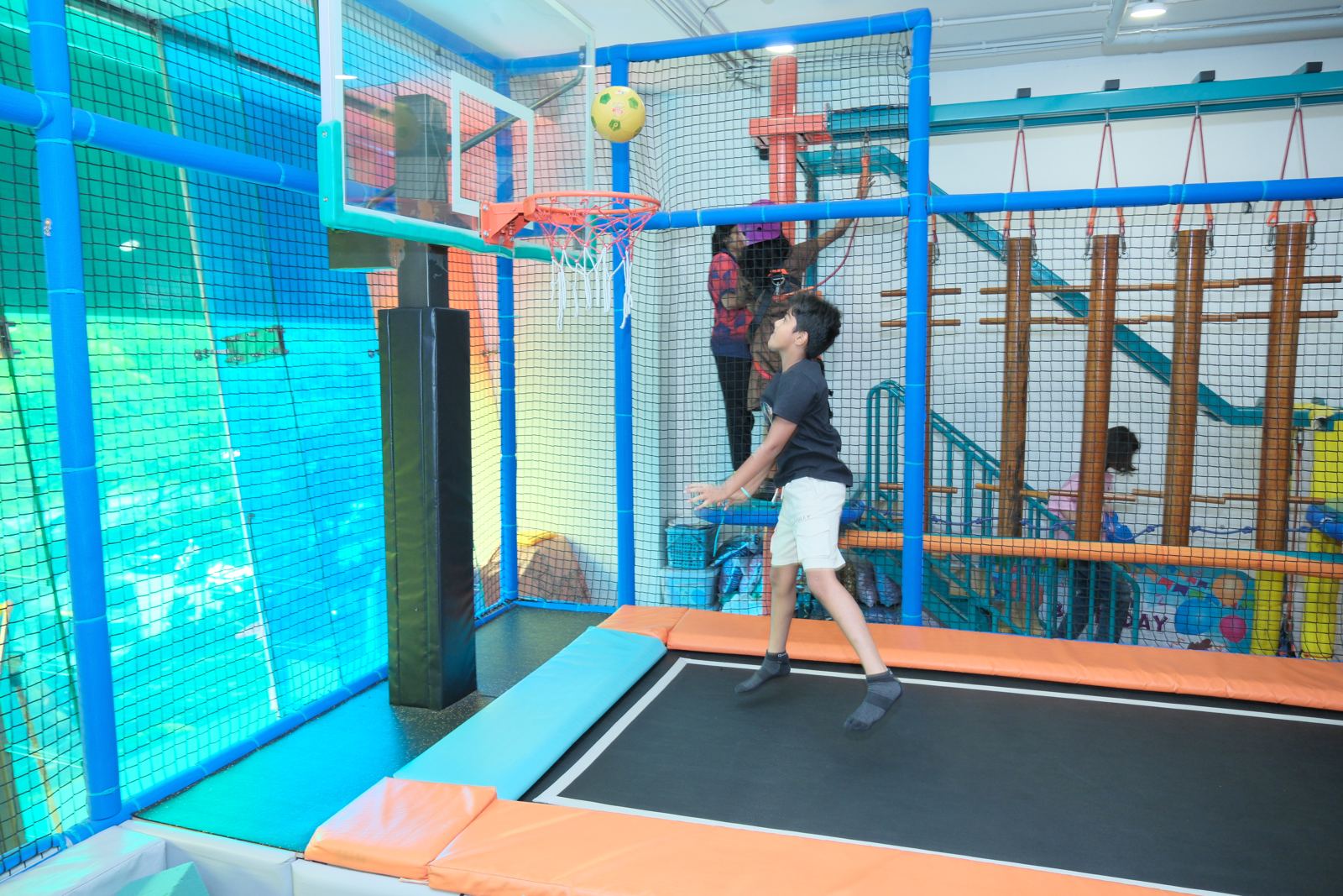 Boy shooting a basketball from the trampoline at Baccha Party Vashi