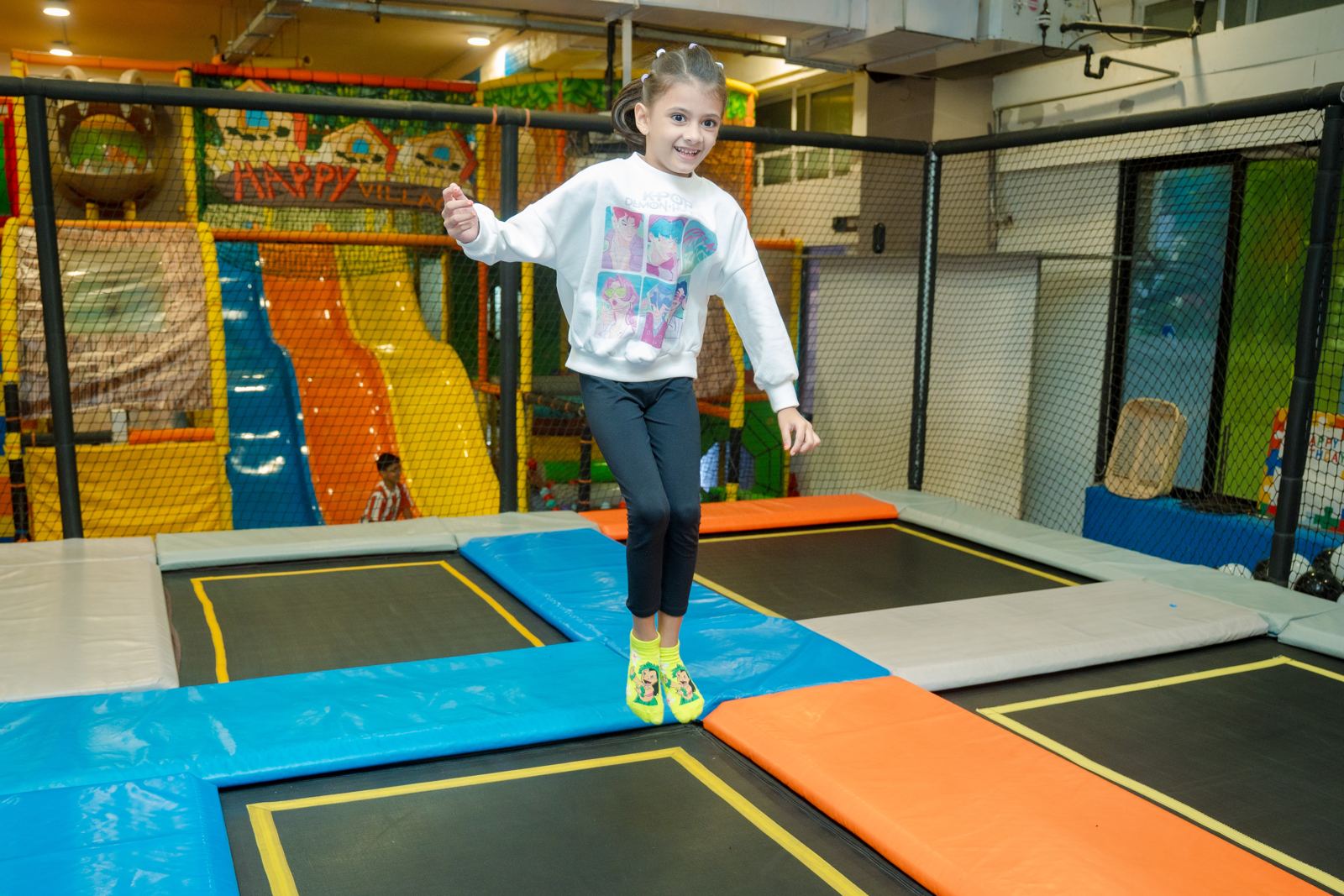 Girl jumping on the trampolines beside the slides at Baccha Party Malad