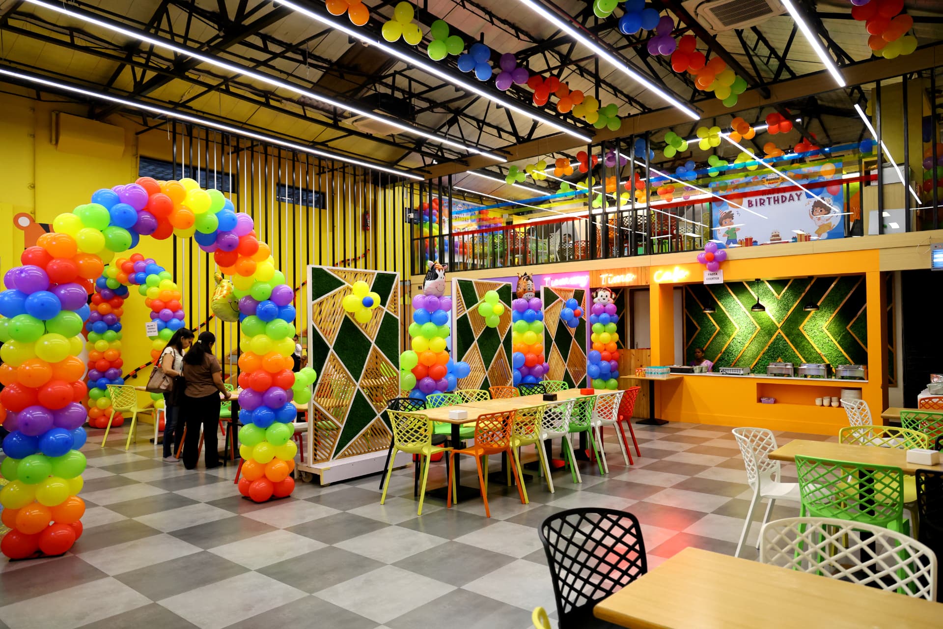 Wide decorated party hall with a balloon arch at Baccha Party Thane