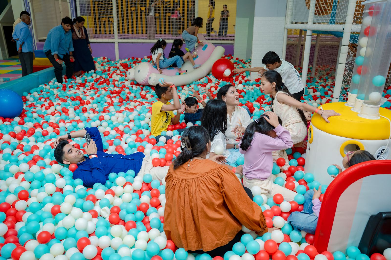 Families relaxing together in the ball pit at Baccha Party Matunga